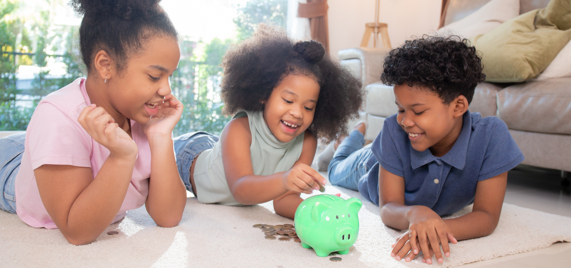 Youth Savings Three children placing coins in a piggy bank